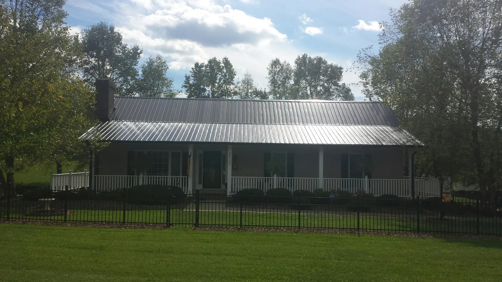 Gray metal roof on a brick ranch with a full width front porch — Gutter Guard Installation work by our crew in Silverstreet