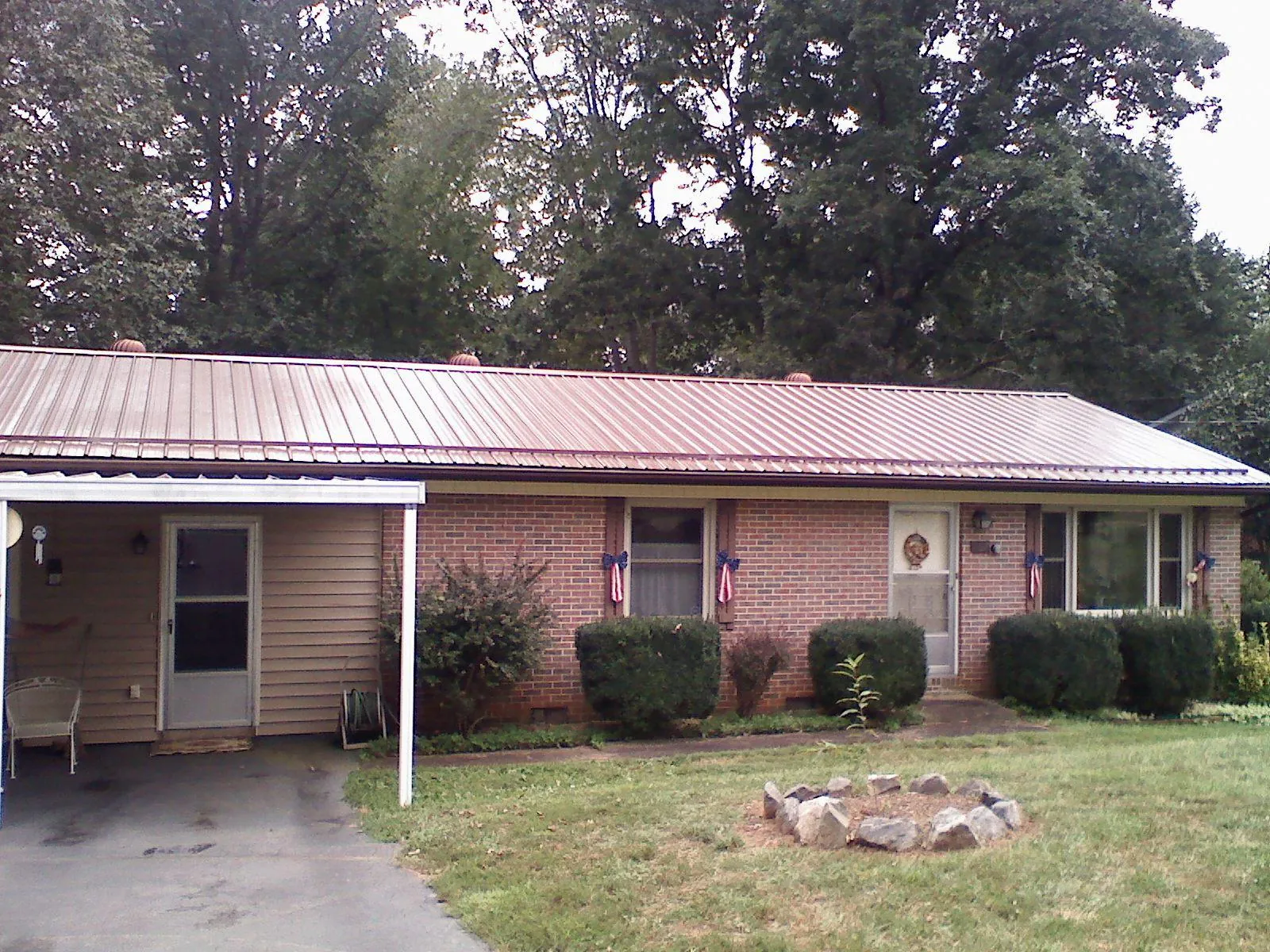 Bronze metal roof and carport on a brick ranch home — Roof Repair work by our crew in Silverstreet